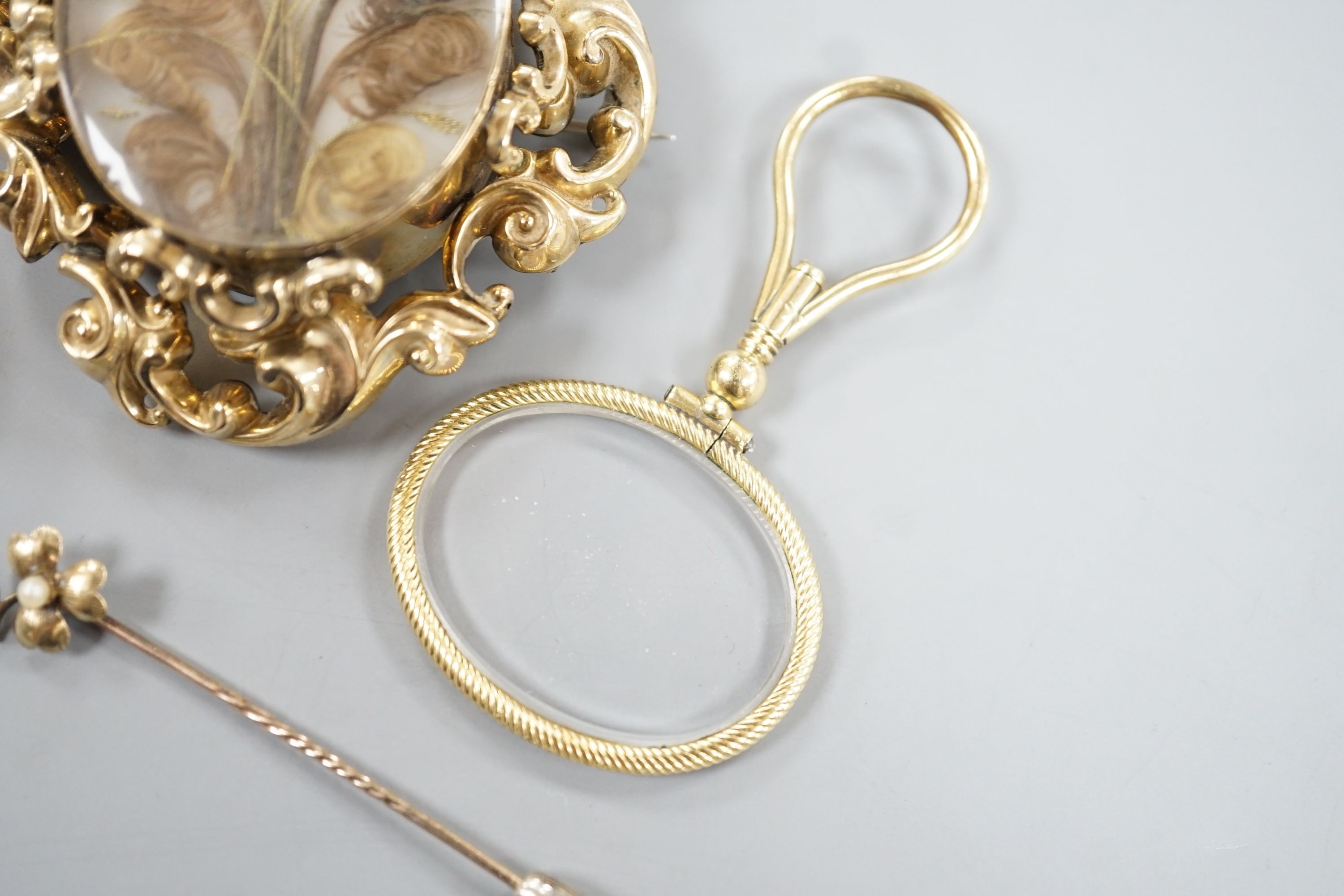 A Victorian yellow metal mounted plaited hair mourning brooch, 6cm, a yellow metal mounted magnifying glass, a similar stick pin and eye glass and a 9ct and gem set bar brooch.
